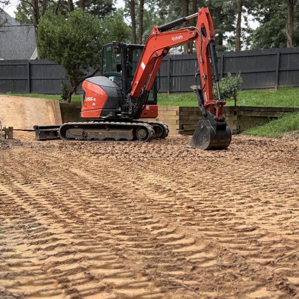Kubota U55 mini excavator performing precision grading and site preparation for a residential backyard after a Pool Demolition project.